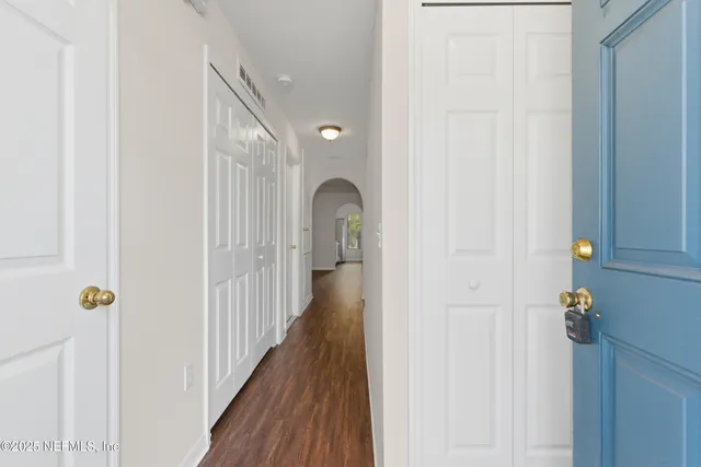 a view of a hallway with wooden floor and entryway