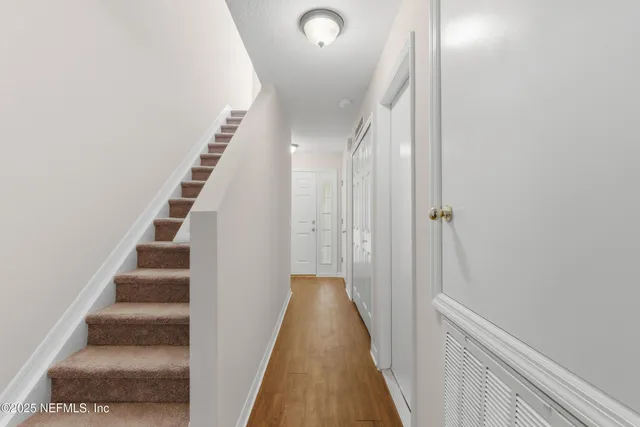 a view of a room with wooden floor ceiling fan and window