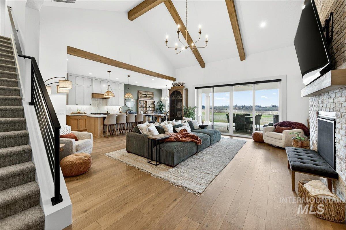 24853 Haflinger Way Middleton, ID 83644 - Photo 12 of 49 Living room featuring a fireplace, light wood-style floors, hanging lights, and vaulted ceiling