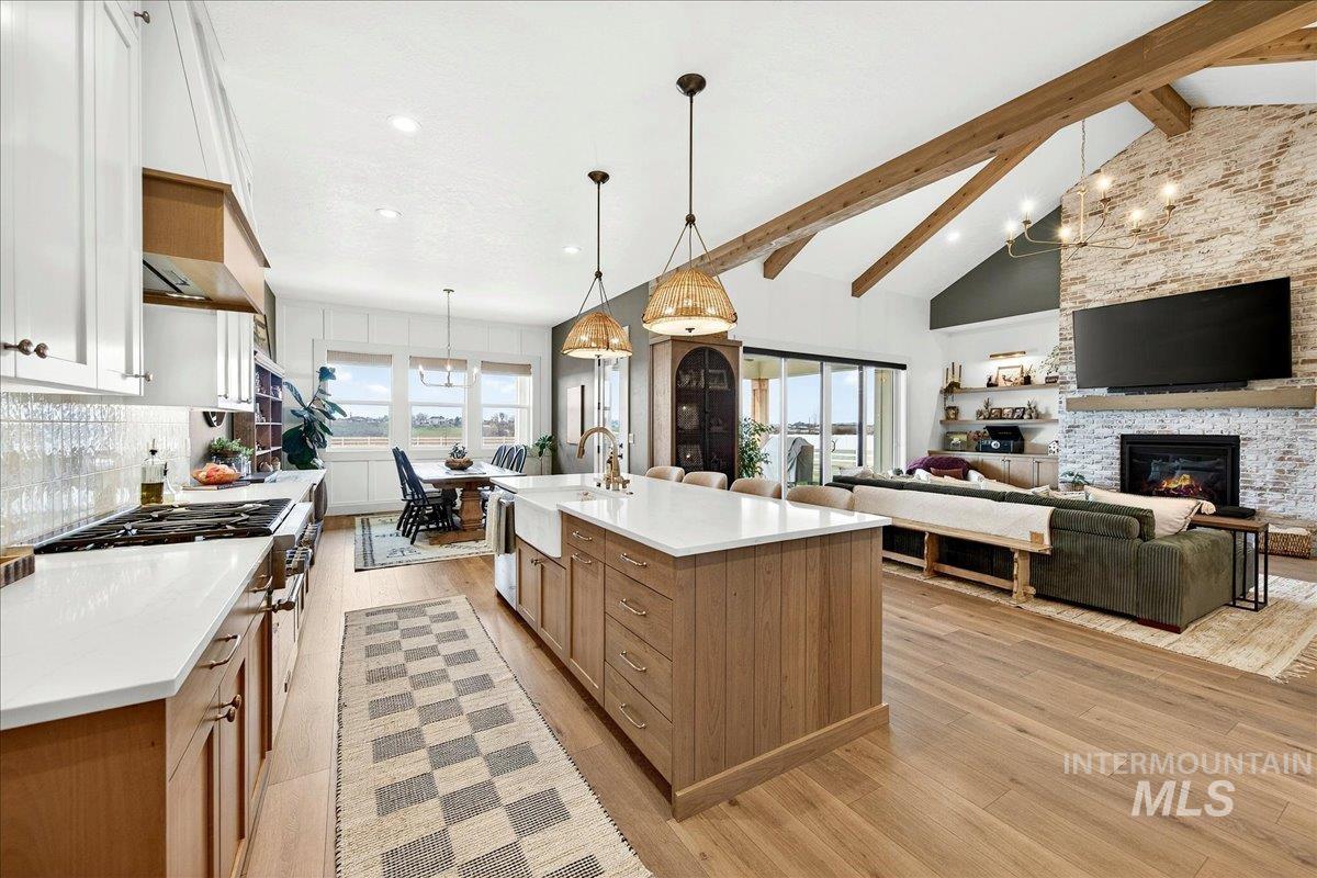 24853 Haflinger Way Middleton, ID 83644 - Photo 48 of 49 Kitchen featuring a large island, open floor plan, suspended lighting, light wood-type flooring, and vaulted ceiling