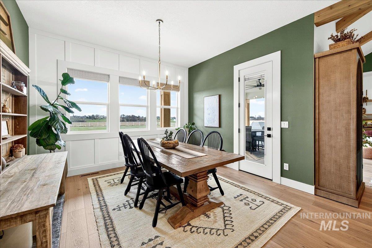 24853 Haflinger Way Middleton, ID 83644 - Photo 20 of 49 Dining space featuring light wood-style floors, suspended lighting, ceiling fan, and a decorative wall