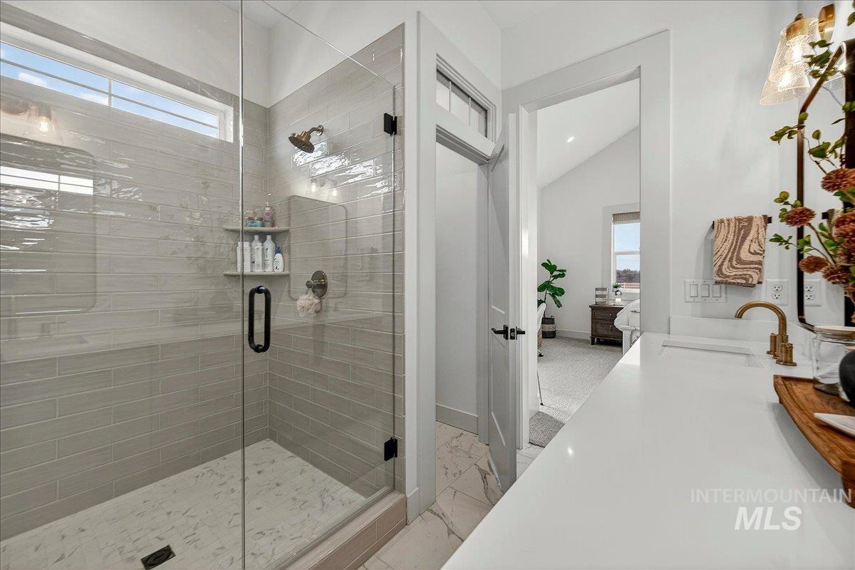 24853 Haflinger Way Middleton, ID 83644 - Photo 33 of 49 Bathroom with a stall shower, vanity, light marble finish flooring, and vaulted ceiling