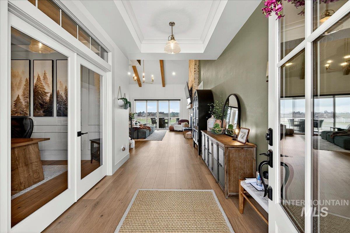 24853 Haflinger Way Middleton, ID 83644 - Photo 6 of 49 Hallway with a chandelier, light wood-style flooring, and a high tray ceiling