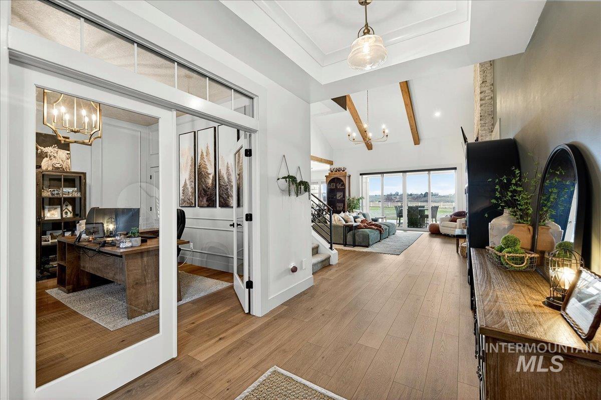 24853 Haflinger Way Middleton, ID 83644 - Photo 7 of 49 Hallway with a chandelier, an office area, light wood finished floors, and vaulted ceiling