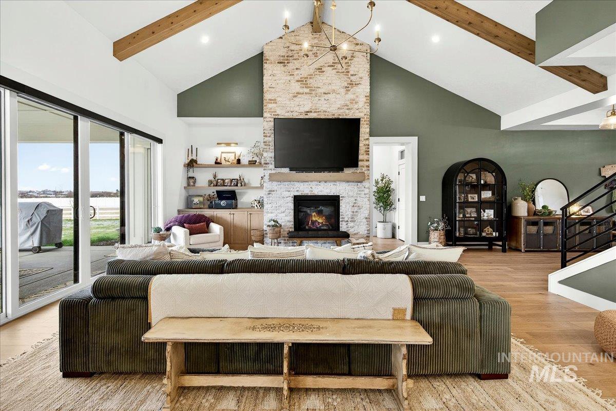 24853 Haflinger Way Middleton, ID 83644 - Photo 9 of 49 Living room with light wood-type flooring, a stone fireplace, and hanging lights