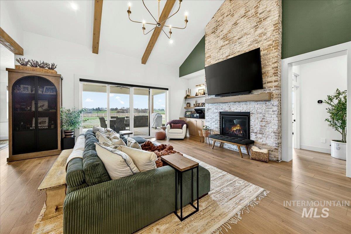 24853 Haflinger Way Middleton, ID 83644 - Photo 10 of 49 Living room with light wood finished floors, suspended lighting, a fireplace, and vaulted ceiling