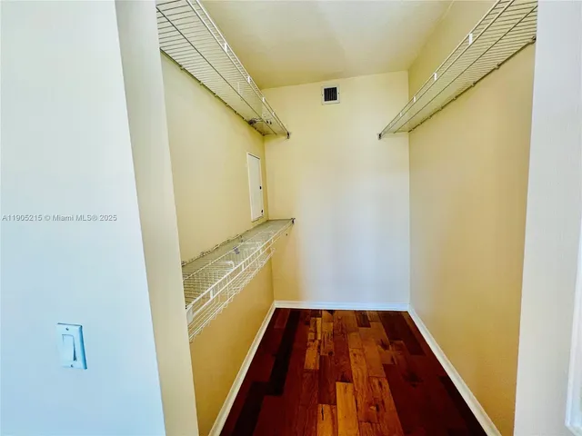 a view of a swimming pool with a lawn chairs under palm trees