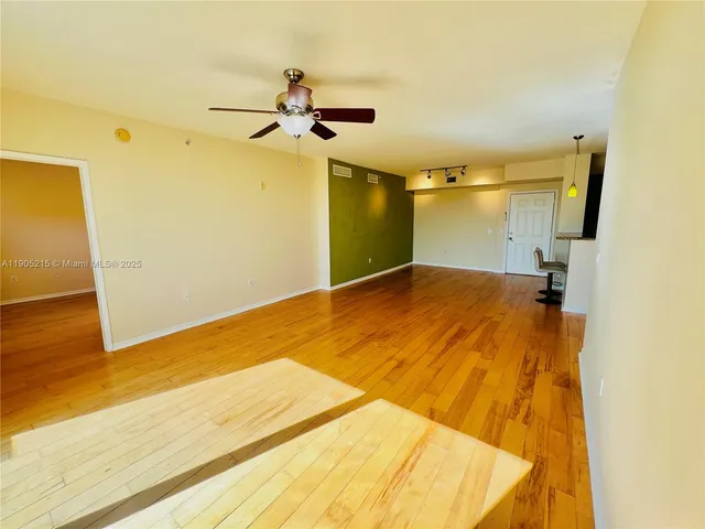 a view of a room with wooden floor and ceiling fan