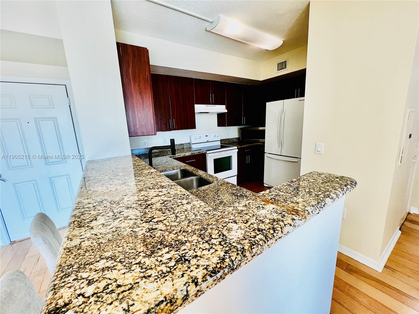 2421 Northeast 65th Street, Unit 506 Fort Lauderdale, FL 33308 - Photo 8 of 59 a kitchen with a sink and a refrigerator