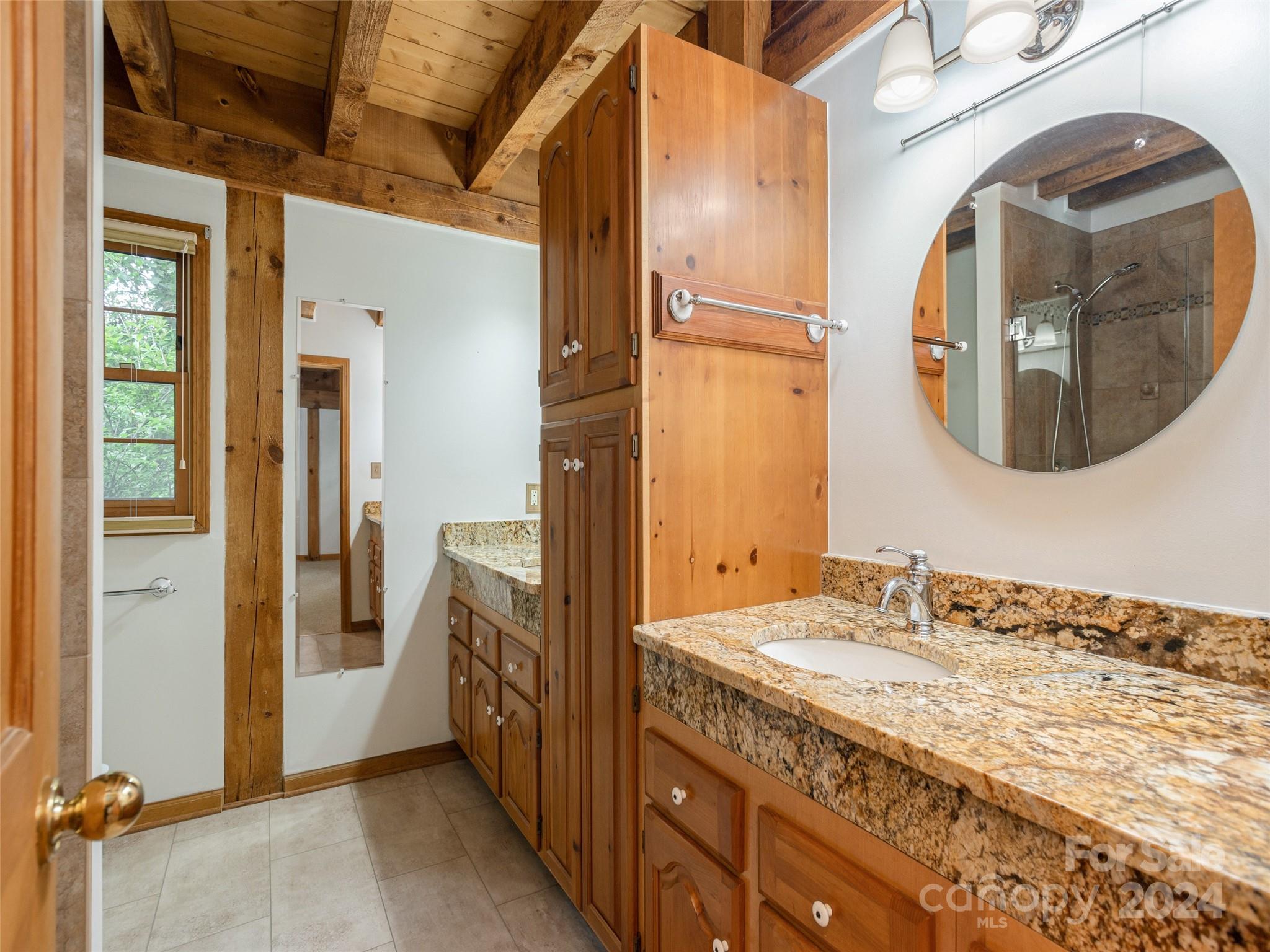28 Chestnut Ridge Road, Unit 228 Mills River, NC 28759 - Photo 20 of 48 a bathroom with a granite countertop double vanity and a mirror