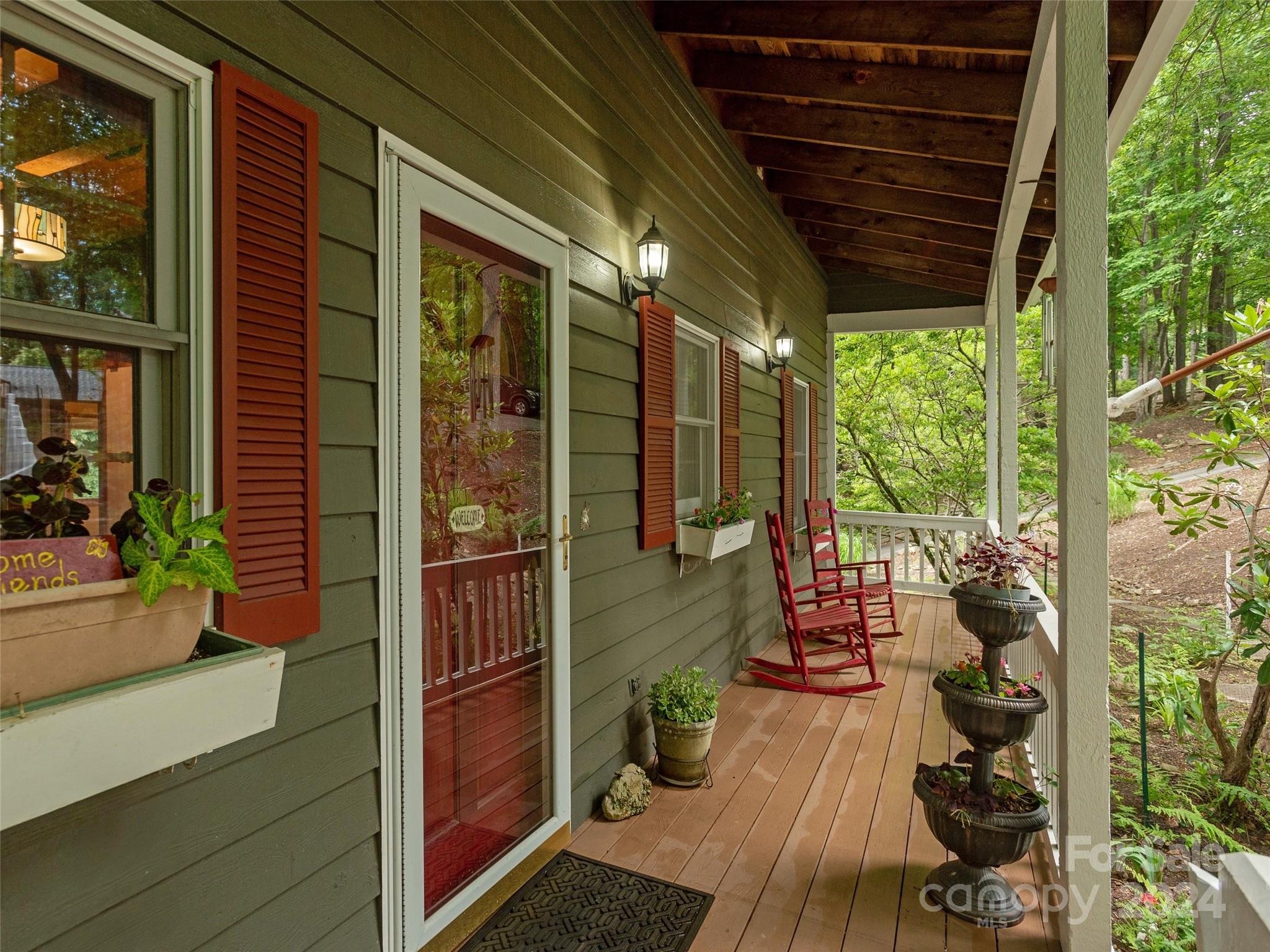 28 Chestnut Ridge Road, Unit 228 Mills River, NC 28759 - Photo 3 of 48 a porch with chairs next to a yard