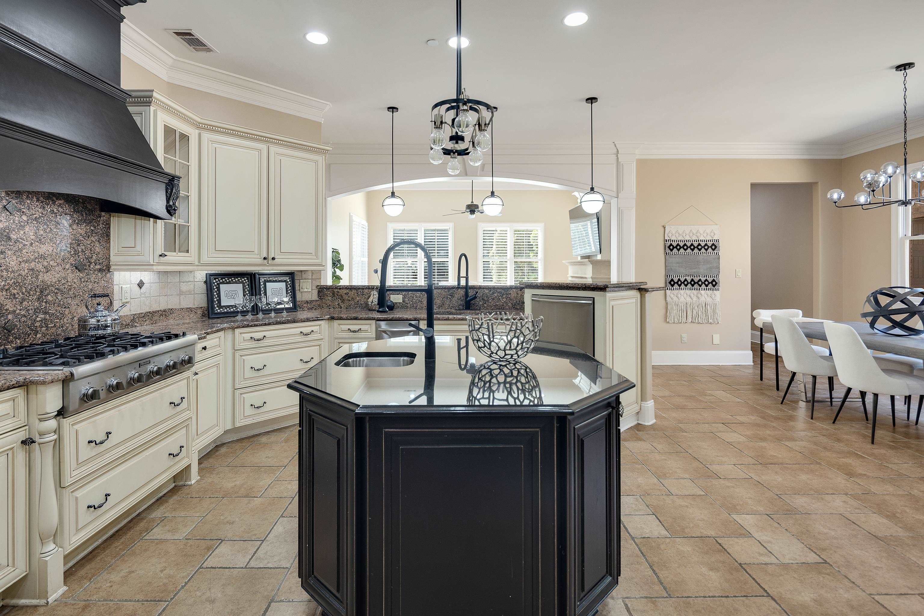 425 Buckland Cove Eads, TN 38028 - Photo 11 of 29 Kitchen featuring cream cabinets, a chandelier, dark cabinets, backsplash, and ornamental molding