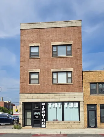 a front view of building with car parked