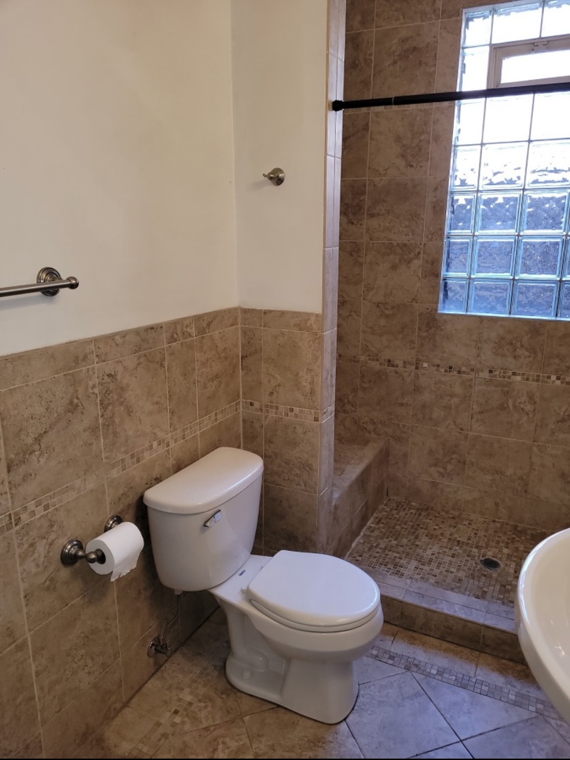 2350 West Grand Avenue Chicago, IL 60612 - Photo 4 of 8 a white toilet sitting next to a bathroom sink and a shower