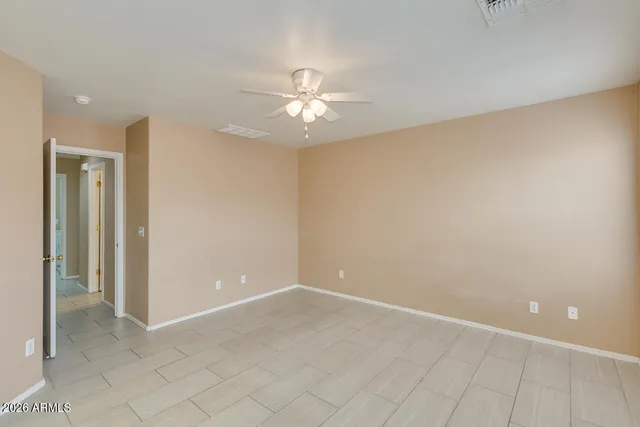 an empty room with closet and a ceiling fan