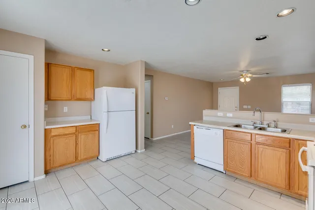 a kitchen with a sink a refrigerator and cabinets