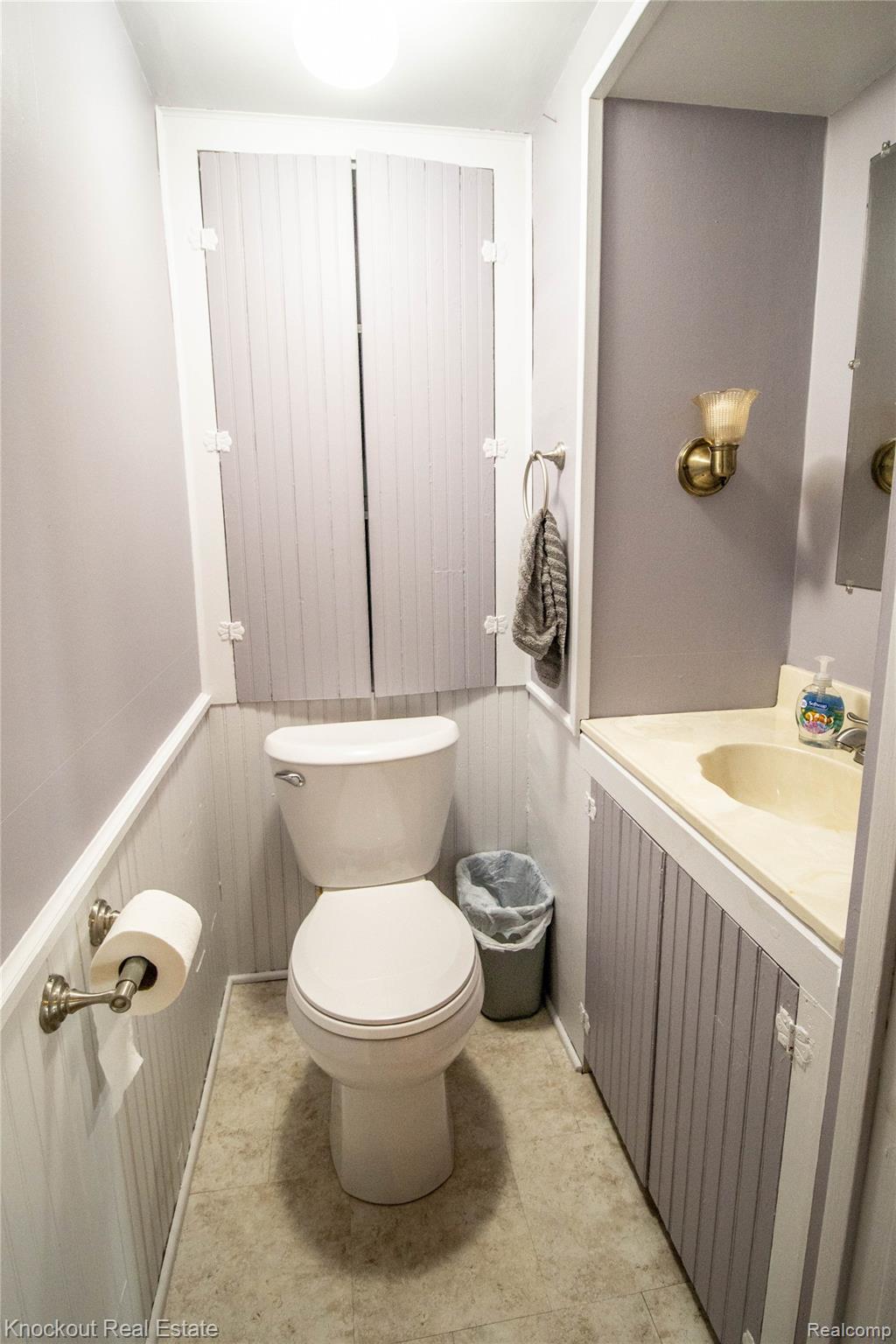 19983 West Ridge Road Henderson, MI 48841 - Photo 28 of 76 Powder room featuring a white toilet, beadboard wainscoting, and a vanity with an integrated sink