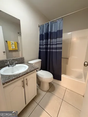 an empty room with a chandelier fan and windows