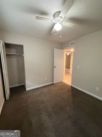 an empty room with windows and fan