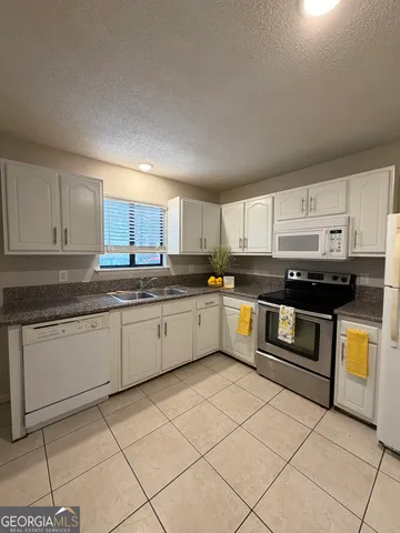a stove top oven sitting inside of a kitchen