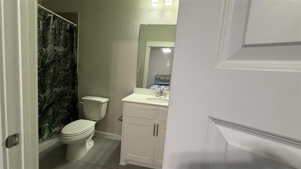912 Fallbrook Avenue Denton, TX 76210 - Photo 21 of 26 a bathroom with a toilet a sink and a shower