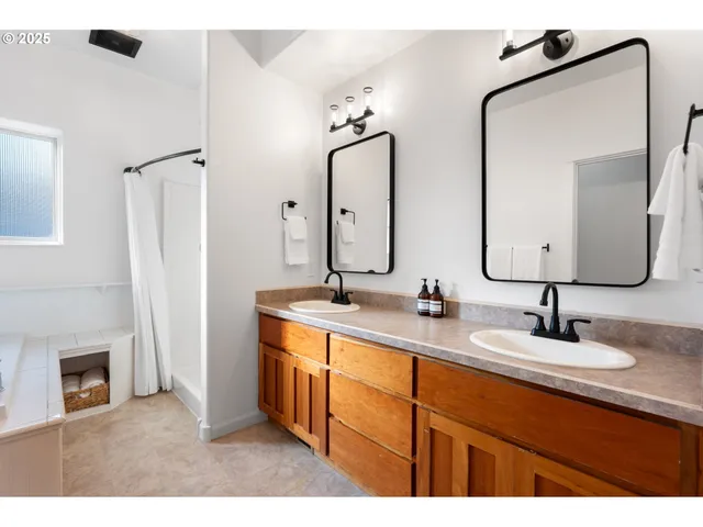 a bathroom with double vanity sinks and a mirror