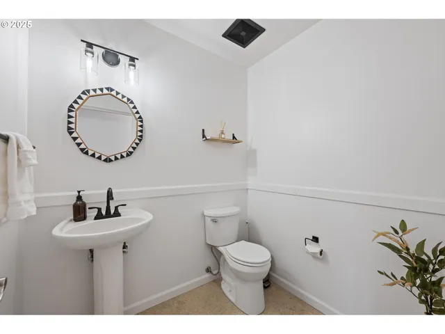 a bathroom with a toilet a sink and a mirror