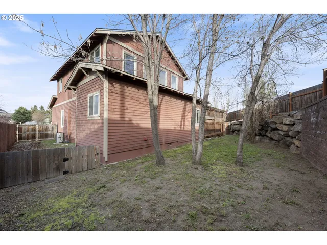 a view of a house with a small yard and wooden fence