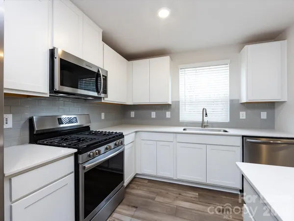 a kitchen with stainless steel appliances granite countertop a sink and a stove