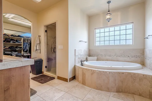 a spacious bathroom with a tub a window and a shower