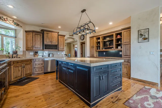 a kitchen with stainless steel appliances granite countertop wooden cabinets and a sink