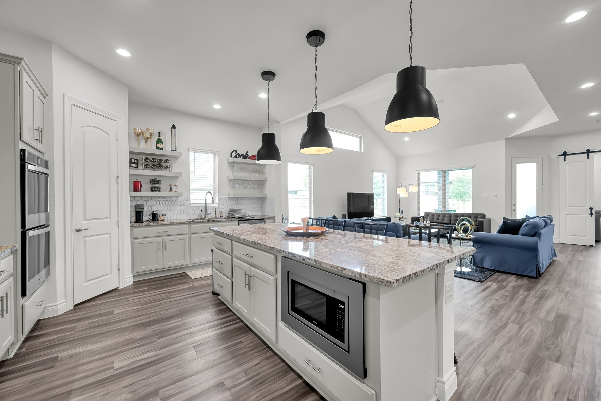 12250 Seagrape Lane Conroe, TX 77304 - Photo 6 of 19 a kitchen with stainless steel appliances granite countertop wooden floors and white cabinets