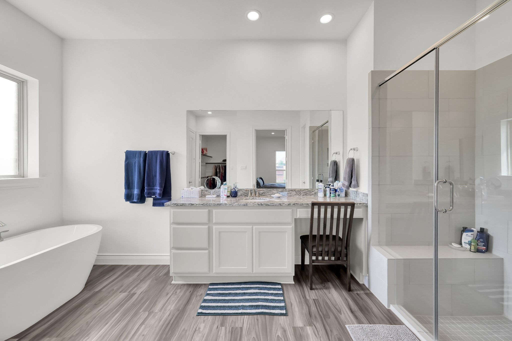 12250 Seagrape Lane Conroe, TX 77304 - Photo 7 of 19 a spacious bathroom with a double vanity sink a mirror and a bathtub