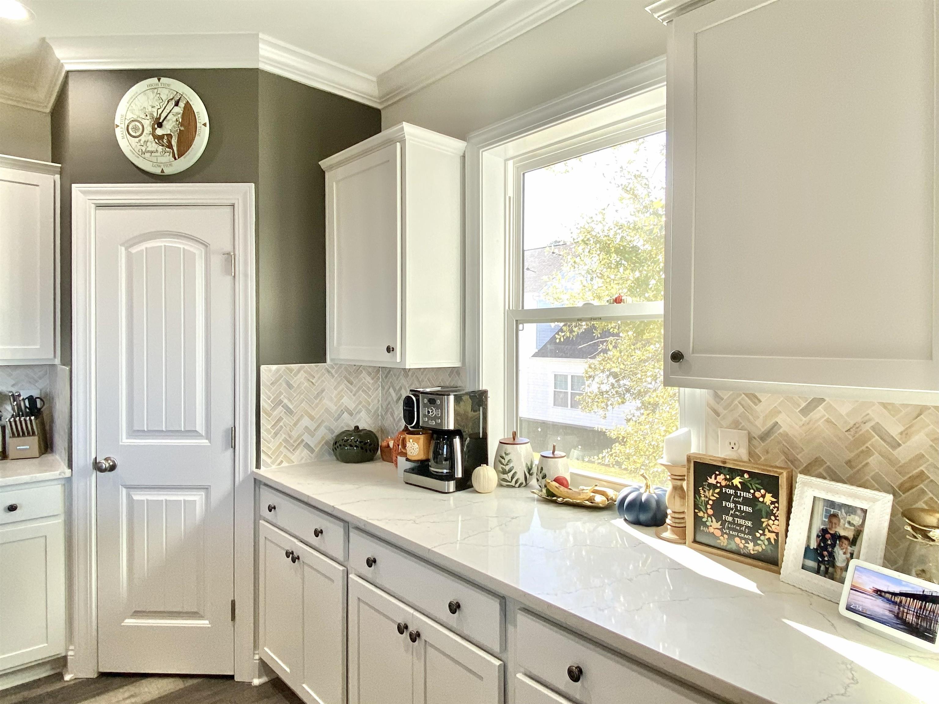 2664 Seaport Circle Georgetown, SC 29440 - Photo 13 of 40 Kitchen featuring backsplash, white cabinets, light stone countertops, crown molding, and dark wood finished floors