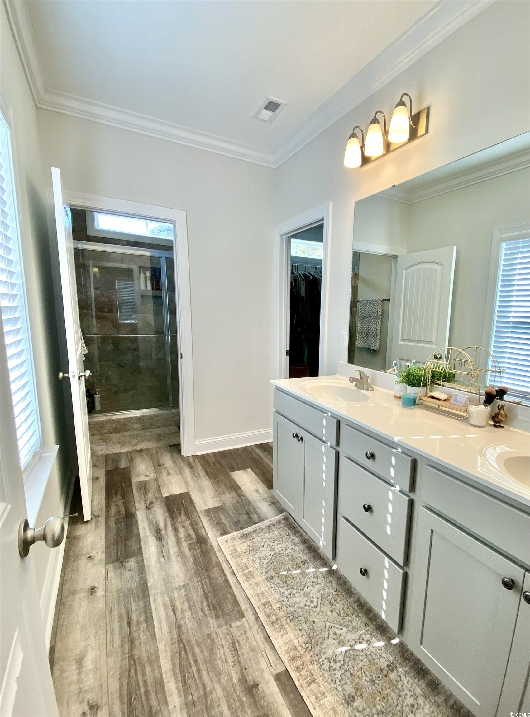2664 Seaport Circle Georgetown, SC 29440 - Photo 21 of 40 Full bathroom with healthy amount of natural light, a stall shower, ornamental molding, double vanity, and light wood-style floors
