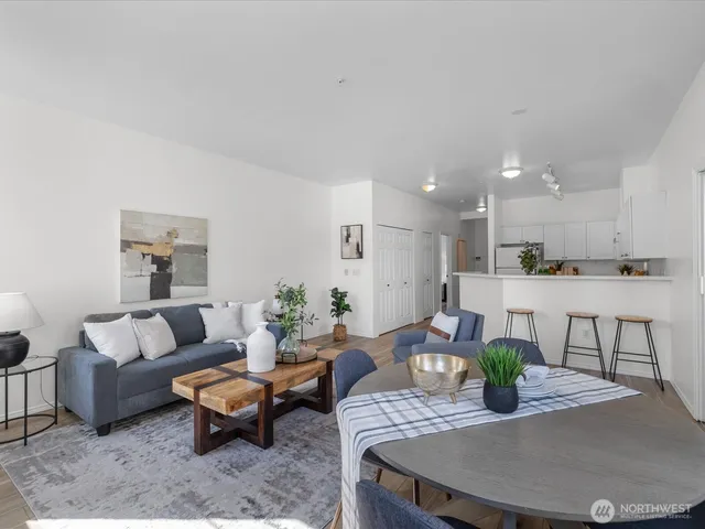 a living room with furniture kitchen view and a potted plant