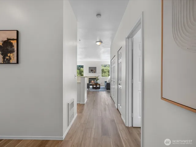 a view of a hallway with wooden floor fireplace and living room