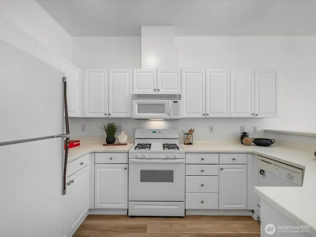 a kitchen with white cabinets and white appliances