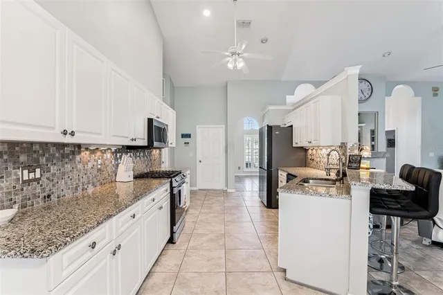 a large white kitchen with lots of counter space and refrigerator