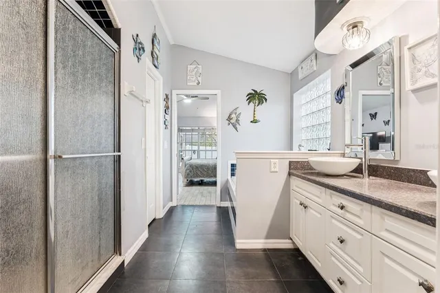 a bathroom with a granite countertop sink a mirror and a shower
