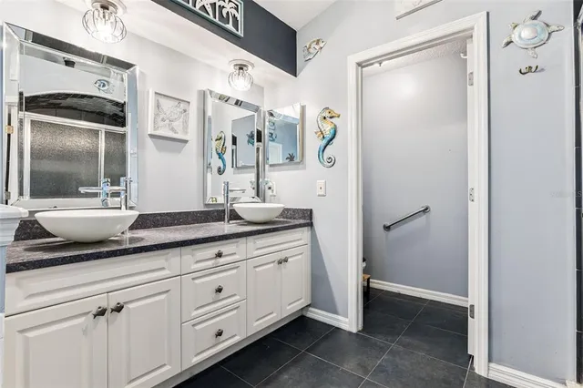 a spacious bathroom with a granite countertop sink and a mirror