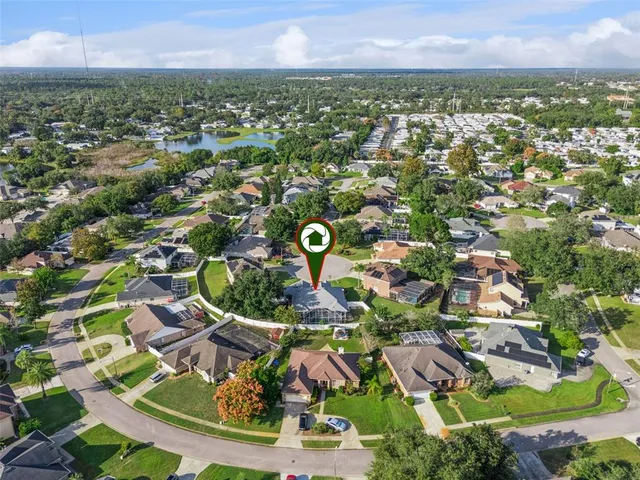 an aerial view of residential houses with outdoor space and trees