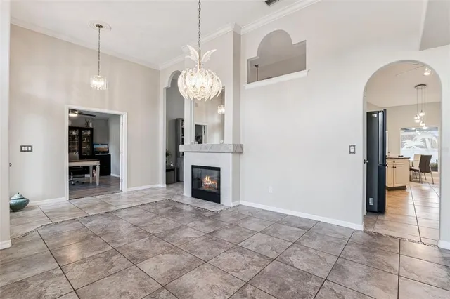 a view of a room with a fireplace cabinet and a chandelier