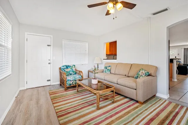 a living room with furniture a chandelier and a rug