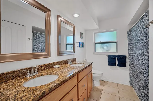 a bathroom with a granite countertop sink a mirror a vanity and a shower