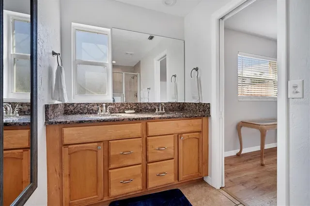 a bathroom with a granite countertop sink and a mirror
