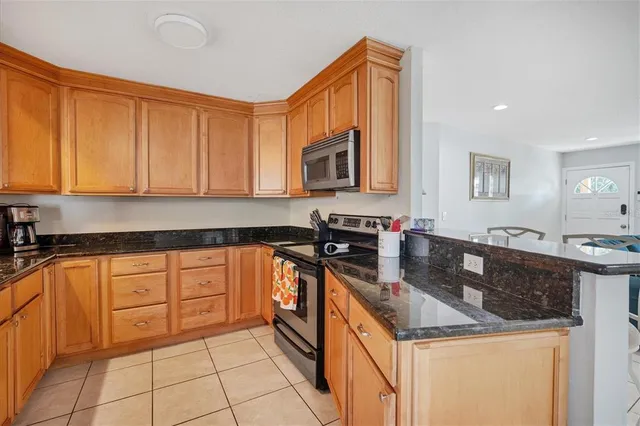 a kitchen with stainless steel appliances granite countertop a stove a sink and a microwave