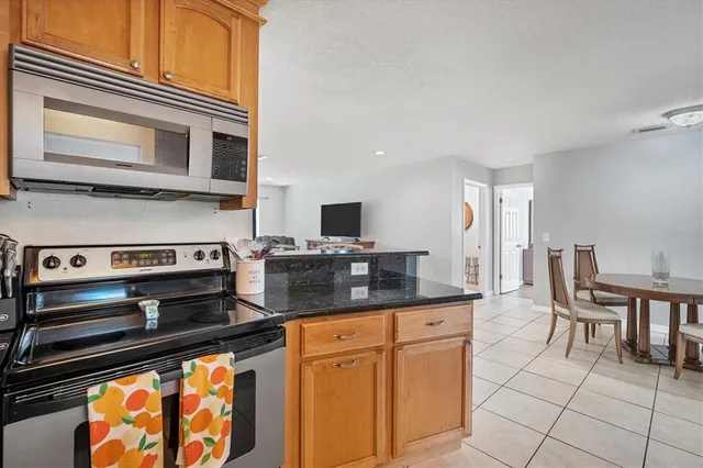 a kitchen with stainless steel appliances granite countertop a stove a sink and a microwave