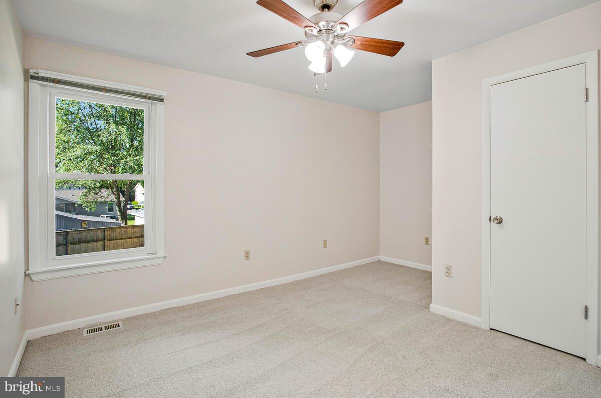 645 Gull Drive Deale, MD 20751 - Photo 27 of 41 an empty room with windows and chandelier fan