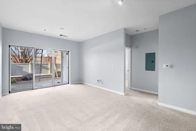 a view of a hallway with wooden floor and a kitchen